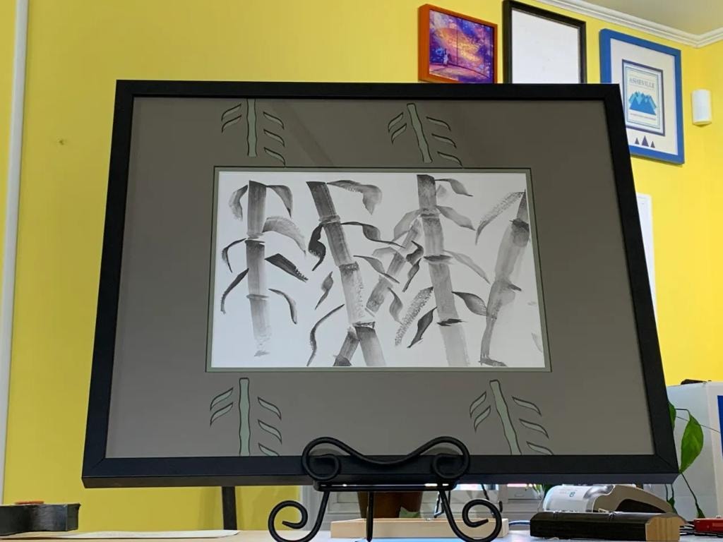 Framed bamboo ink drawing on yellow wall