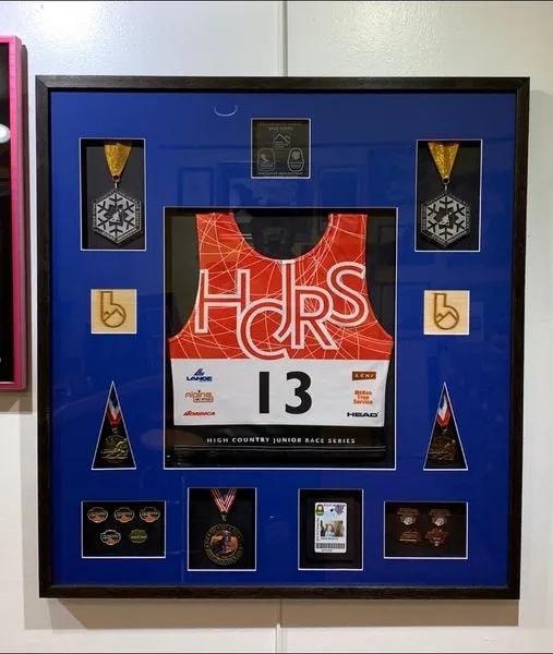 Framed racing jersey with medals and memorabilia