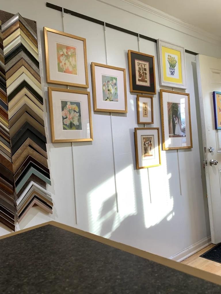 Shop display wall with framed artwork and moulding samples
