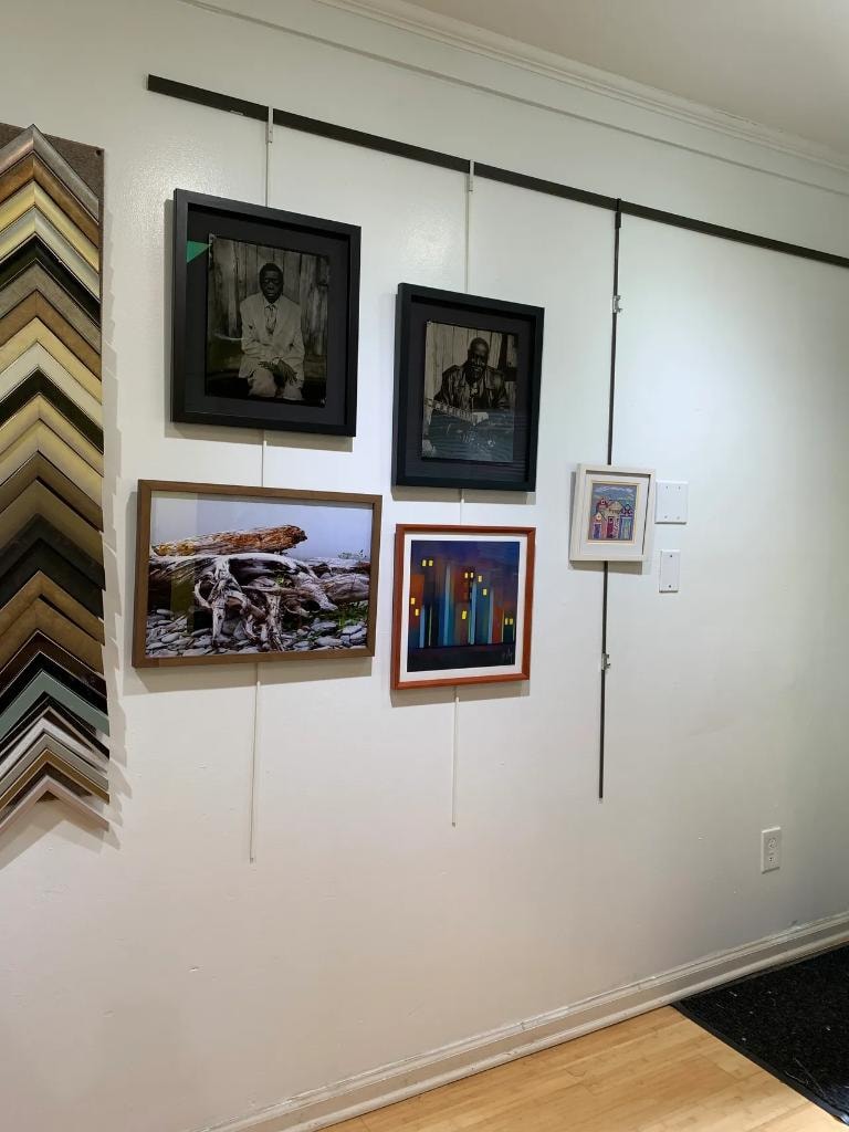 Shop gallery wall with framed portraits and artwork